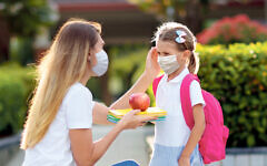 Mother and her child wear masks as students head back to school during the pandemic Mother and her child wear masks as students head back to school during the pandemic