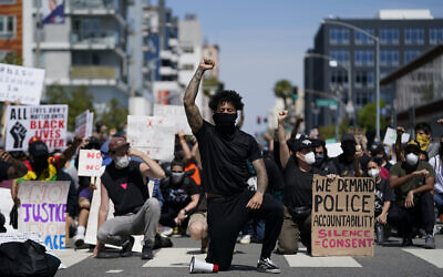 Demonstrators kneel in a moment of silence outside the Long Beach Police Department on Sunday, May 31, 2020,   (AP Photo/Ashley Landis)