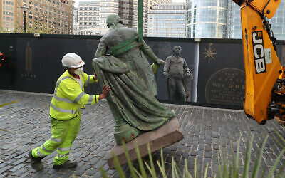 Workers take down a statue of slave owner Robert Milligan at West India Quay, east London as Labour councils across England and Wales will begin reviewing monuments and statues in their towns and cities, after a protest saw anti-racism campaigners tear down a statue of a slave trader in Bristol. PA Photo. Picture date: Tuesday June 9, 2020. The Charity Canal and River Trust, which owns the land where the statue is located, issued a statement on Twitter following a petition launched by Tower Hamlets Labour councillor Ehtasham Haque, which demanded the removal of the figure. See PA story POLICE Floyd Statues. Photo credit should read: Yui Mok/PA Wire