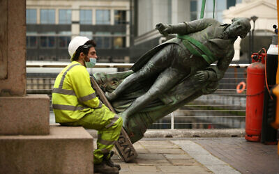 A worker sits down as they take down a statue of slave owner Robert Milligan at West India Quay, east London (Photo credit: Yui Mok/PA Wire)