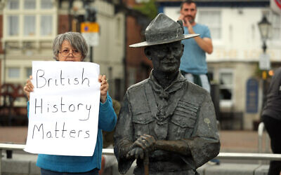 A person with a sign protesting 'British History Matters' alongside the statue of Robert Baden-Powell on Poole Quay in Dorset. (Photo credit: Andrew Matthews/PA Wire)