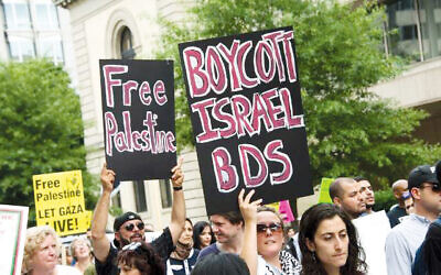Protestors with signs urging the boycott of Israel