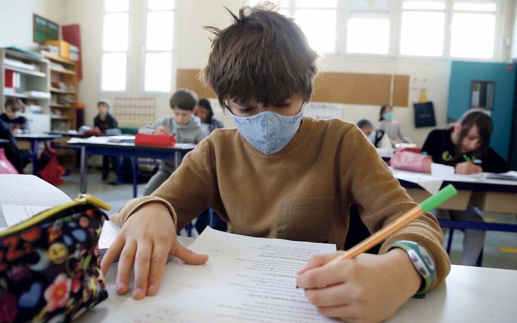 Children keep social distancing and sanitary measures as they go back to school