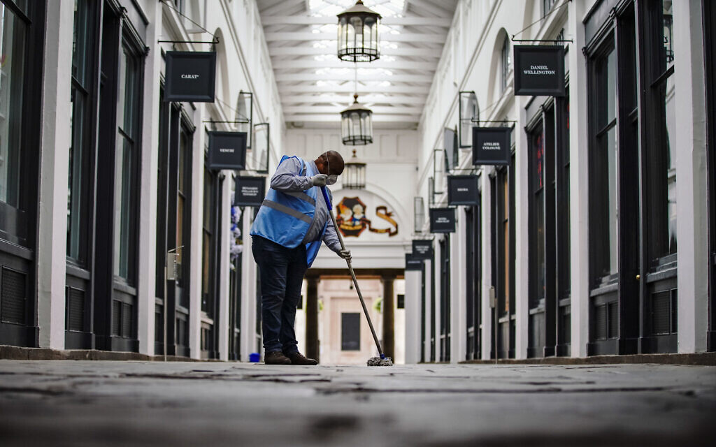 A man cleans social distancing markers in Covent Garden, London as further coronavirus lockdown restrictions are lifted in England. (Credit: Aaron Chown/PA Wire)