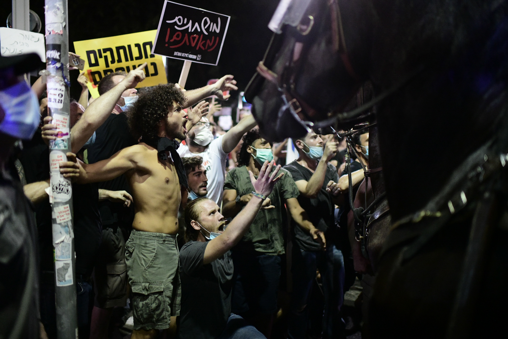 Israelis wearing protective face masks due to the COVID-19 coronavirus pandemic, take part in a demonstration on July 18, 2020, in the Israeli coastal city of Tel Aviv to protest against the Israeli government and Prime Minister Benjamin Netanyahu for the broken promises made by the Israeli government during the Covid-19 pandemic. - Israel's government said today it was imposing new restrictions to limit the spiraling spread of coronavirus in the hope of avoiding a general lockdown further along the line. Photo by: Tomer Neuberg-JINIPIX