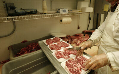 A butcher cuts and packs lamb chops (AP Photo/Wilfredo Lee)