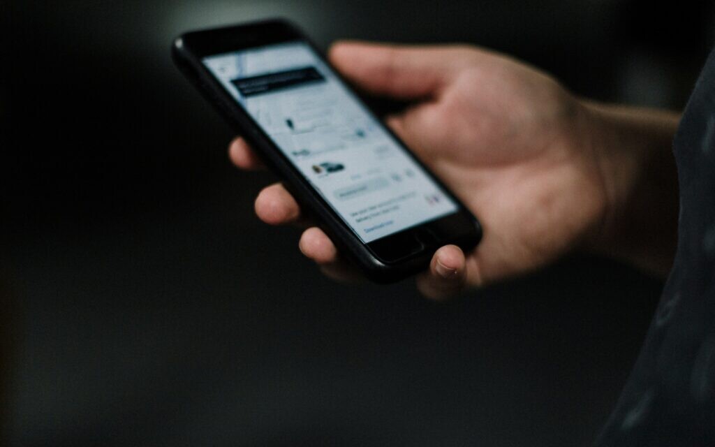 Stock image of a person holding a phone (Credit: Priscilla Du Preez on Unsplash)
