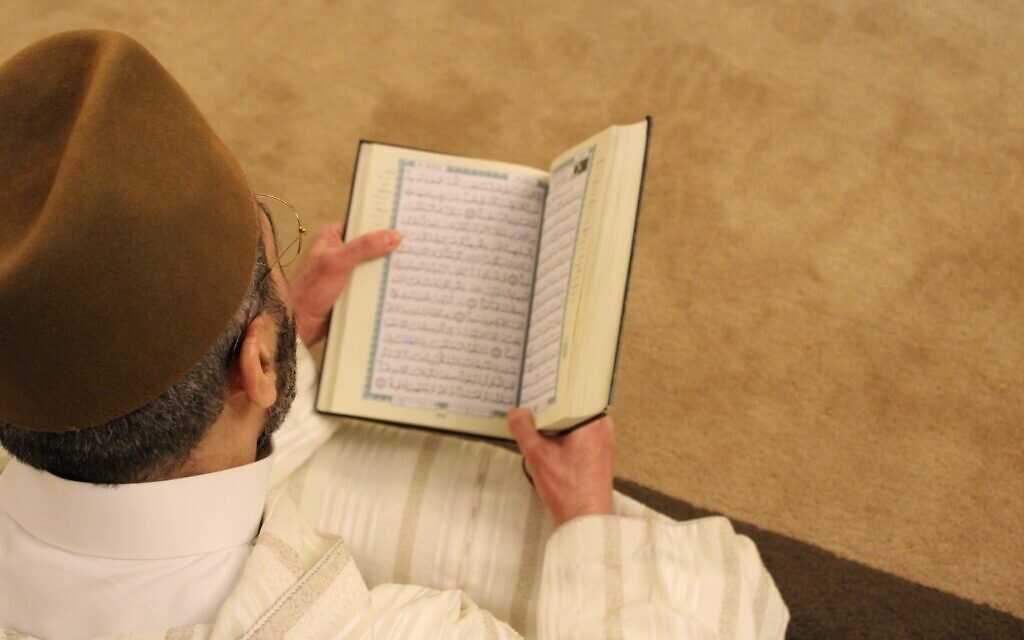 Man reading an Islamic prayer book - the Quran (Photo by Rachid Oucharia on Unsplash)