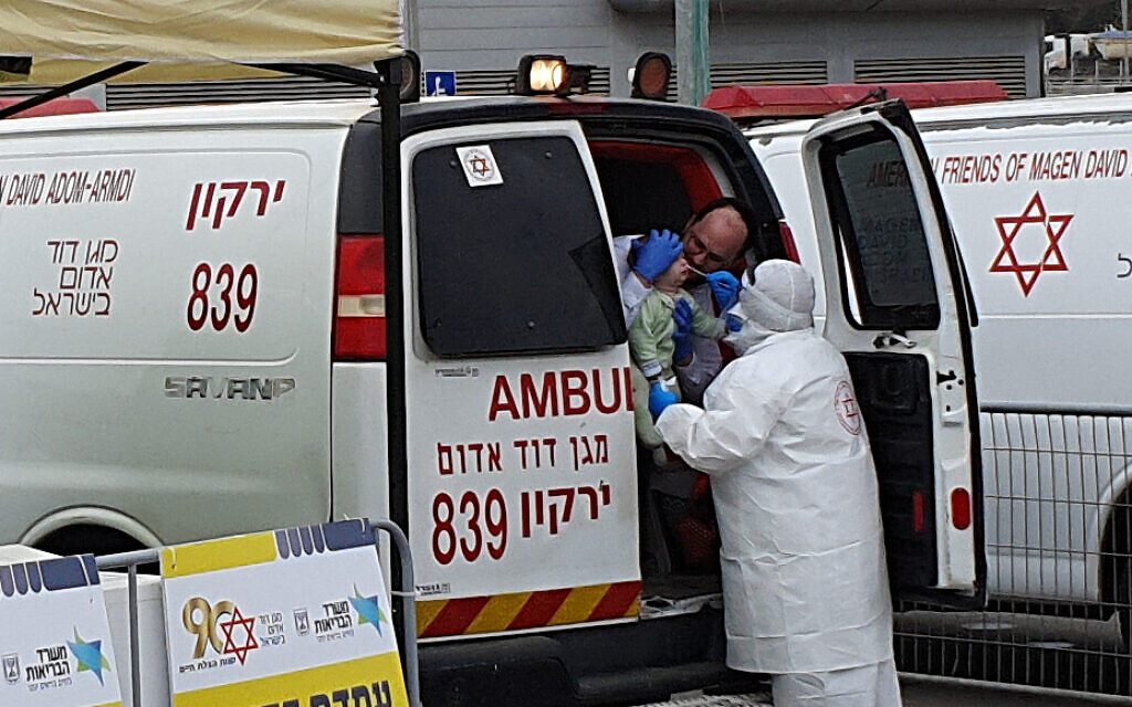 Magen David Adom staff check a young person for Covid-19