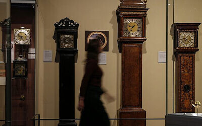 A woman walks past grandfather clocks on display at the Clockmakers' Museum, part of the Science Museum in London.