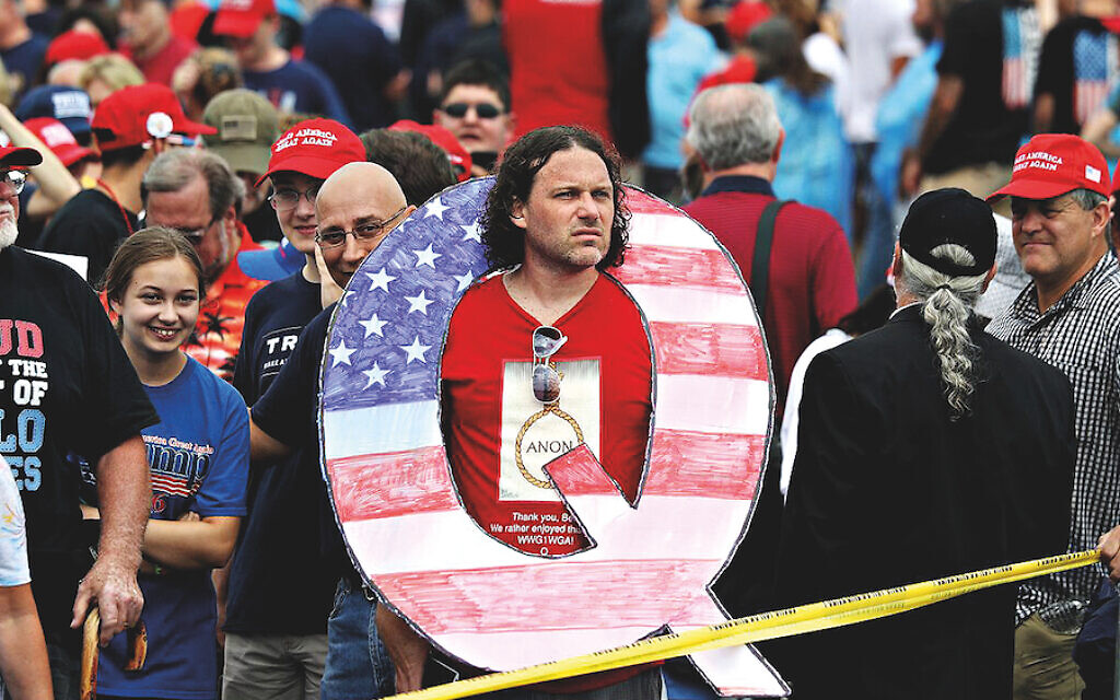 A President Trump supporter wears a giant Q at a political rally 