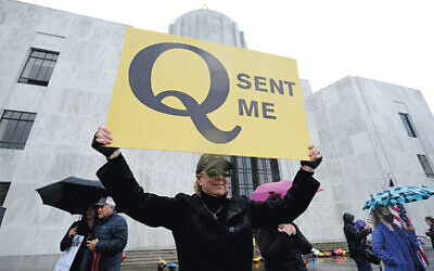 A woman holds a QAnon sign at a protest in Washington, DC