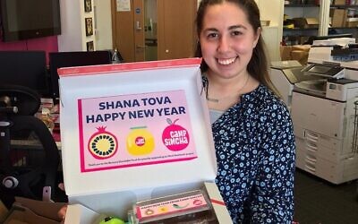 Camp Simcha volunteer Shearly Cohen with a box which will be sent out for Rosh Hashanah