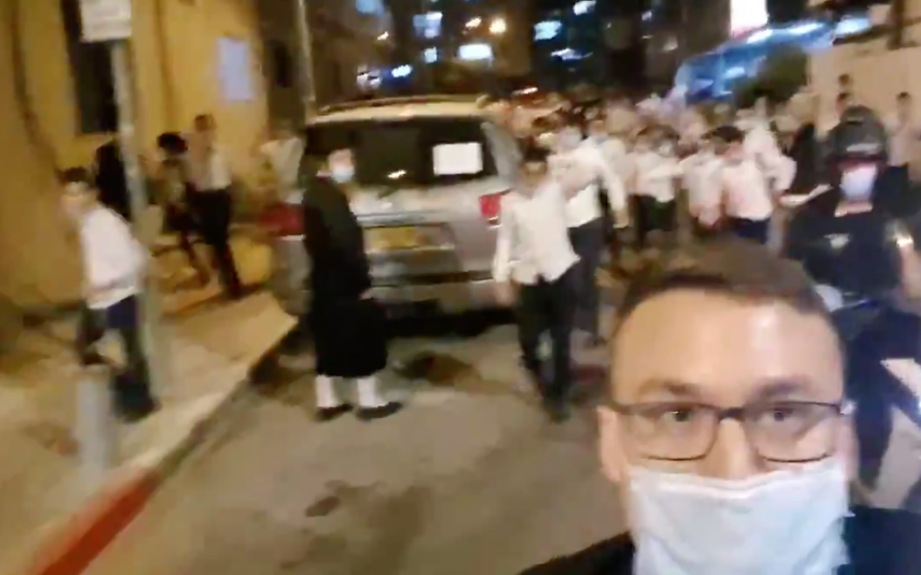 In Bnei Brak, Israel, reporter Ittai Shickman films himself chased by a mob of Charedi Jews while standing outside the home of a prominent rabbi. (Screen shot from Twitter via JTA)