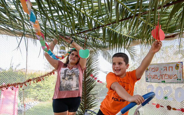 Children decorate a sukkah on October 1, 2020. Photo by: Ayal Margolin-JINIPIX