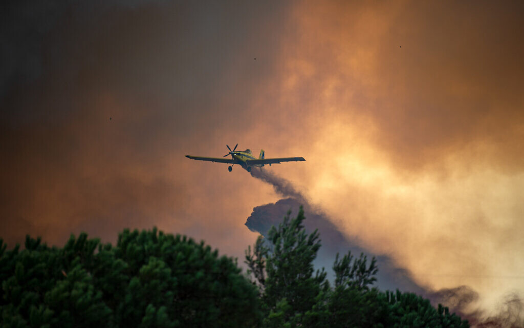 A firefighting plane try to extinguish a forest fire blazes near Nof HaGalil on Friday 9 October 2020. Some 200 police and volunteers accompanied by additional forces have evacuated about 5,000 residents from their homes in the northern city of Nof HaGalil on Friday as massive wildfires raged in the area. Photo by: Gil Eliyahu-JINIPIX