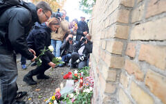 People leave flowers and candles in memory of the victims of the attack in Halle, Germany