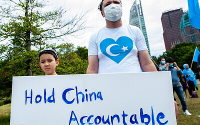 A man and his child holding a placard against China during the demonstration.
  (Photo by Ana Fernandez / SOPA Images/Sipa USA)