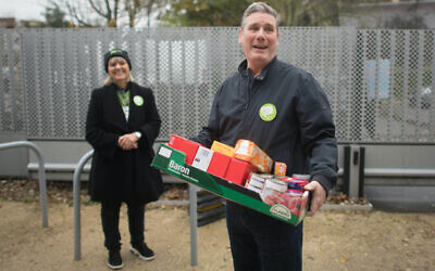Labour leader, Sir Keir Starmer helps with distributing food parcels at South Hampstead Synagogue in north London today to mark Mitzvah Day. He is pictured with Mitzvah Day founder Laura Marks (PA media/ Stefan Rousseau)