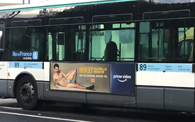 A RATP bus with a billboard of Sacha Baron Cohen wearing a ring with the word Allah on it moves through Paris, France on Nov. 2, 2020. (Courtesy of @firehairedreamr/Twitter via JTA)