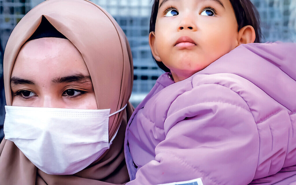A member of the Muslim Uighur minority holds a child in her arms as she demonstrates in front of the Chinese consulate on December 30, 2020, in Istanbul, to ask for news of her relatives and to express her concern after China announced the ratification of an extradition treaty with Turkey. - The Chinese parliament ratified on December 26, 2020 an extradition treaty signed in 2017 with Ankara, a text that Beijing wants to use in particular to speed up the return of certain Muslim Uyghurs suspected of "terrorism" and who are refugees in Turkey. But the head of Turkish diplomacy said on December 30, 2020 that Ankara was not going to return Muslim Uyghurs to China, despite Beijing's ratification of an extradition treaty that worries the 50,000 members of this community who have taken refuge in the country. (Photo by BULENT KILIC / AFP) (Photo by BULENT KILIC/AFP via Getty Images)