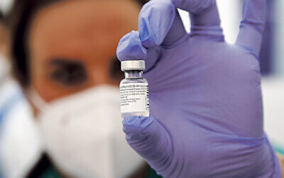 A nurse holds a phial containing the Pfizer-BioNTech Covid-19.