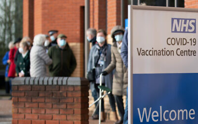 People wait to receive their Covid-19 vaccine at an NHS vaccine centre