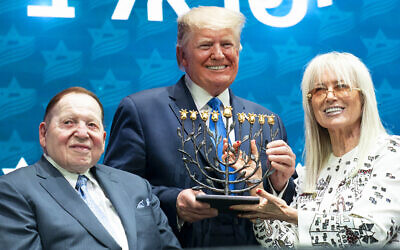 President Donald J. Trump receives a menorah from Miriam and Sheldon Adelson at the Israeli American Council National Summit Saturday, Dec. 7, 2019, in Hollywood, Fla. (Official White House Photo by Joyce N. Boghosian) (Wikipedia/ Source:	President Trump at the Israeli American Council National Summit
Author: The White House from Washington, DC / Public domain)