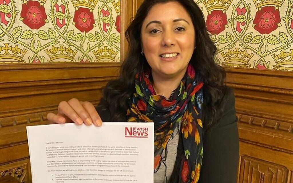 Nus Ghani holding the Uyghur petition signed by 150 Parliamentarians