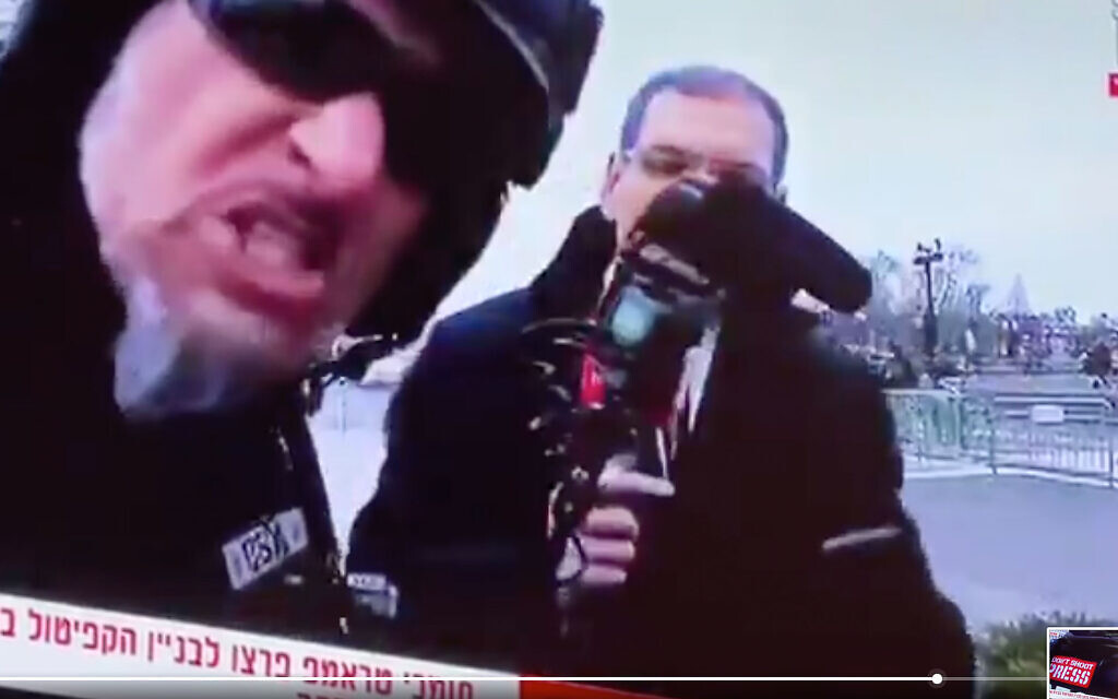 A protestor harasses Israeli journalist Gil Tamari and levels antisemitic slurs. (Screen shot)