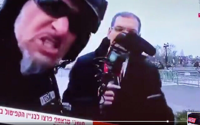 A protestor harasses Israeli journalist Gil Tamari and levels antisemitic slurs. (Screen shot)
