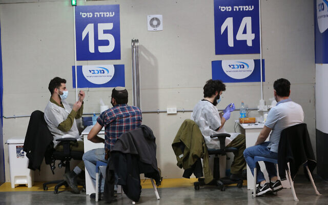 People wait to receive COVID-19 vaccines in central Israeli city of Givatayim,   (Photo by Muammar Awad/Xinhua)