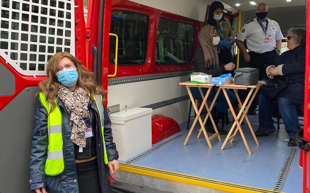 Dr Sharon Raymond next to the mobile vaccination unit