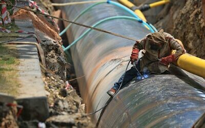 Man fixing a pipeline (Photo by SELİM ARDA ERYILMAZ on Unsplash)