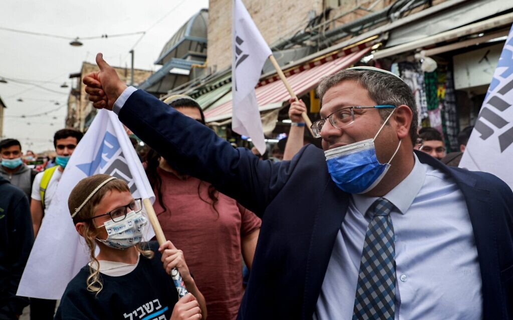 Itamar Ben Gvir (R), head of Israel's Jewish Power (Otzma Yehudit) party, cheers to supporters at the Mahane Yehuda market in Jerusalem