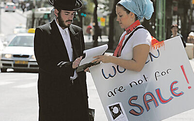 A man signs a petition at a demonstration for women's rights held outside the rabbinical court for divorces