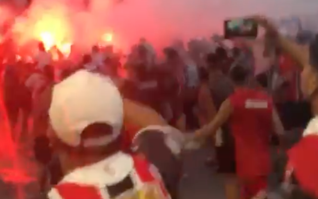 A screenshot from the viral video of Chacarita fans chanting an anti-Semitic line shows them marching near a bonfire on the street. (Screenshot via JTA)