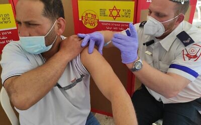 A Palestinian worker receives a shot of the Moderna vaccine from an Israeli paramedic (Photo: Magen David Adom)