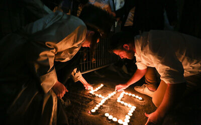 Ultra orthodox jews light candles for the 45 victims who were killed in a stampede, at the scene of the fatal disaster, at Mt Meron. Photo by David Cohen/Flash90.