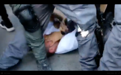Ofer Cassif being held by police. (Screenshot from Twitter)