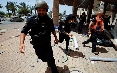 Israeli police run near the scene where a rocket from Gaza landed in Ashkelon on Tuesday (Photo: Reuters/Nir Elias)