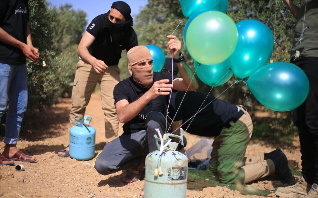 Masked young Palestinians, filled balloons with Helium Gas then they connect it with flammable object before they transport the balloons towards Israel. Credit: Mahmoud Khattab/Quds Net News/ZUMA Wire/Alamy Live News