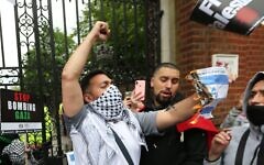 A protester burns the Israeli flag. A protester burns the Israeli flag.