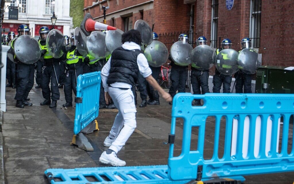 A rioter throws a traffic cone at police during the clashes A rioter throws a traffic cone at police during the clashes