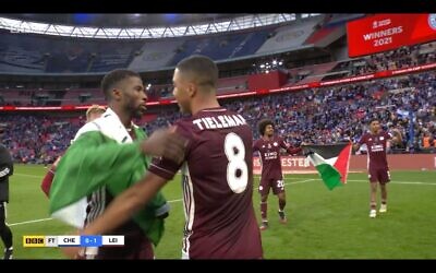 Screenshot from the BBC of two Leicester players holding a Palestinian flag