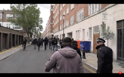 Screenshot shows police officer with a demonstrator as antisemitic chants are made
