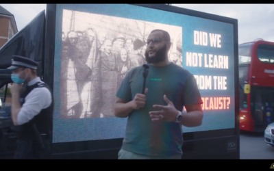 Mohammed Hijab in front of an electronic banner asking if Jews have 'learned from the Holocaust'