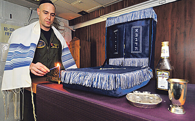 Jewish lay leader of the Nimitz-class aircraft carrier USS Harry S. Truman (CVN 75), lights a candle celebrating the 1st night of Hanukah in the ship's chapel.   (U.S. Navy photo by Mass Communication Specialist 2nd Class Kilho Park/Released)