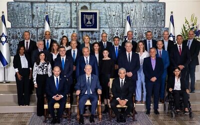 Israeli Prime Minister Naftali Bennett, seated left, President Reuven Rivlin, seated center, and Alternate Prime Minister and Minister of Foreign Affairs Yair Lapid seated right, pose for a group photo with the ministers of the new government at the President's residence in Jerusalem, Monday, June 14, 2021. Photo by: JINIPIX