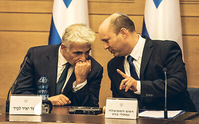 New Israeli Prime Ministers Naftali Bennett (R), leader of the Yamina right-wing alliance, and Yair Lapid, leader of the Yesh Atid opposition centrist party attend first cabinet meeting at the Israeli Parliament (Knesset).